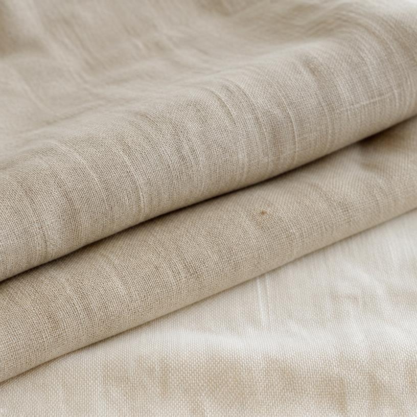 Folded natural linen fabric in warm oat tones